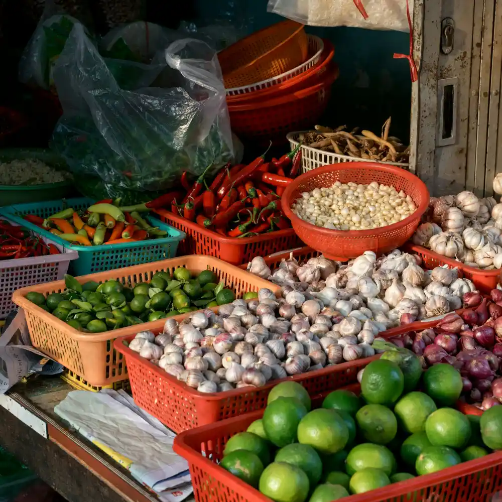 Rổ ớt, tỏi, chanh và rau bày bán ở chợ quê buổi sáng